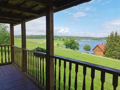 a view from the deck of a cabin with a view of a lake at Sodyba 