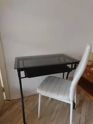a white chair sitting under a black desk with a table at Link Kauno marių... in Kaunas