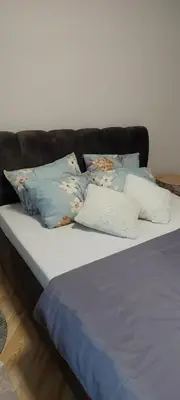 a bed with several pillows on top of it at Link Kauno marių... in Kaunas
