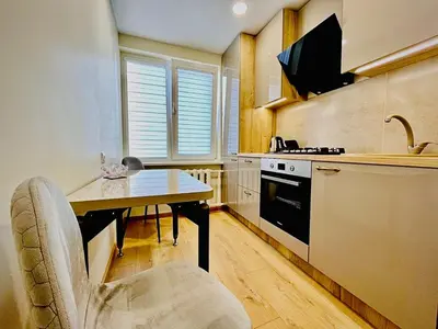 a kitchen with a table and a chair in a kitchen at M&M Apartment VI SELF CHECK-IN in Panevėžys