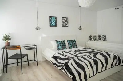 a bedroom with a zebra print bed and a desk at Šviesos Apartamentai in Anykščiai