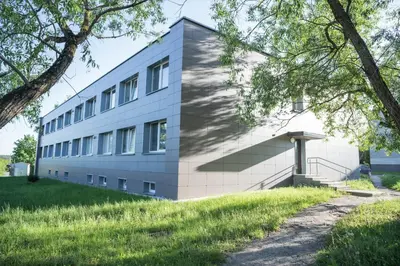 an office building with stairs and grass at Šviesos Apartamentai in Anykščiai