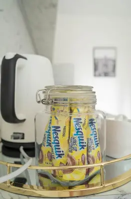 a jar of snacks sitting on a rack in a kitchen at Šviesos Apartamentai in Anykščiai