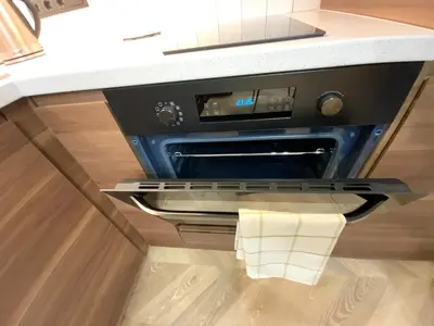 an oven in a kitchen with a white counter top at Alėjos Apartmentai City in Druskininkai