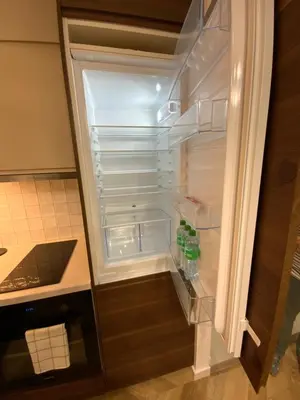 an empty refrigerator with its door open in a kitchen at Alėjos Apartmentai City in Druskininkai