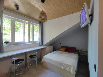 a bedroom with a bed and a desk with stools at Cosy Apartments in Vilnius Center in Vilnius