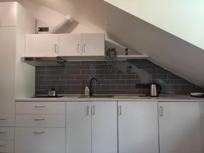 a kitchen with white cabinets and a staircase at Cosy Apartments in Vilnius Center in Vilnius