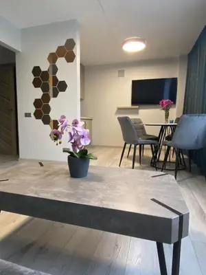a living room with a table with flowers on it at ADI Apartamentai in Panevėžys