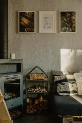 a living room with a fireplace and a fire place at Private cosy forest cabin in Inturkė