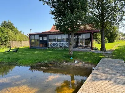 a house with a pond in front of it at Chill House in Miežonys