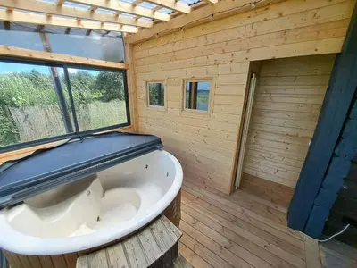 a bathroom with a white tub in a wooden wall at Chill House in Miežonys
