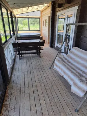 a screened in porch with a bench and a swing at Chill House in Miežonys