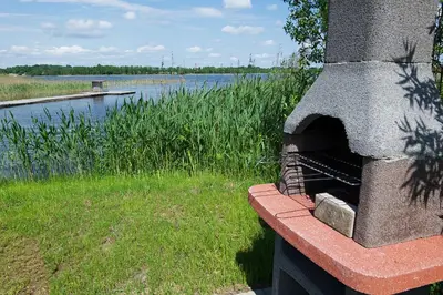 a brick oven sitting next to a body of water at Chill House in Miežonys