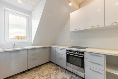 a kitchen with white cabinets and a sink and a window at Shanghai Banzai Family Apartment Vilnius in Vilnius