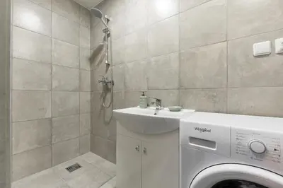 a bathroom with a washing machine and a sink at Shanghai Banzai Family Apartment Vilnius in Vilnius