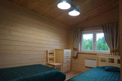 a bedroom with two beds and a window at R&M Resort in Petkėniškės