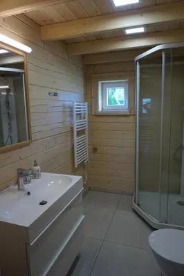 a bathroom with a sink and a shower at R&M Resort in Petkėniškės
