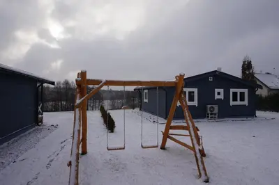 a swing set in a yard in the snow at R&M Resort in Petkėniškės