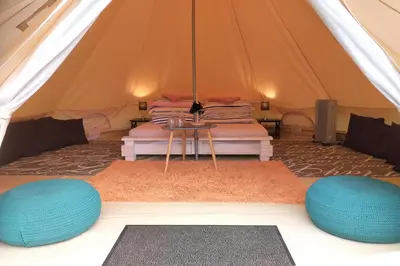 a tent with two beds and a table in it at Natur Camp Glamping Birštonas in Birštonas