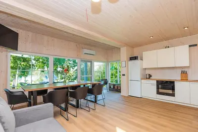 a kitchen and dining room with a table and chairs at Namelis ant ežero kranto 
