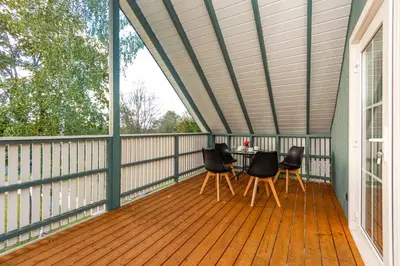 a screened porch with a table and chairs on it at Namelis ant ežero kranto 