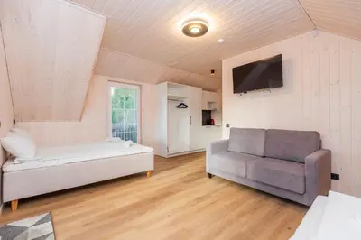 a bedroom with a bed and a couch and a chair at Namelis ant ežero kranto 