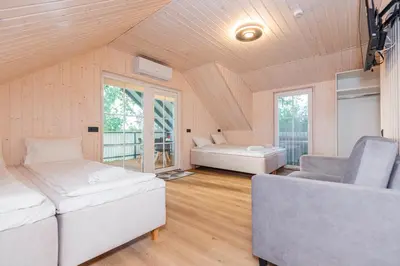 a room with two beds and a couch and a chair at Namelis ant ežero kranto 