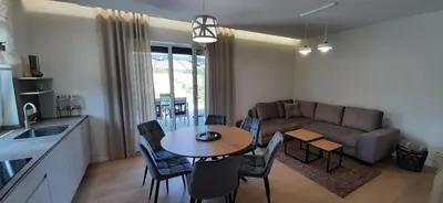 a kitchen and living room with a table and a couch at Vila Galadusis prie ežero in Lazdijai