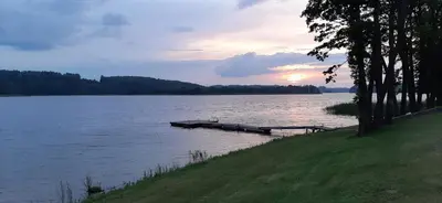 a lake with a dock in the middle of it at Vila Galadusis prie ežero in Lazdijai