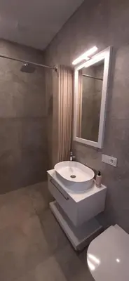 a bathroom with a sink and a toilet and a mirror at Vila Galadusis prie ežero in Lazdijai