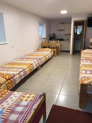 a group of beds in a room with a kitchen at Rooms for Rent near Vilnius in Bezdonys