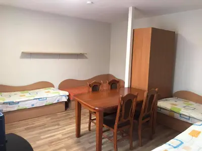 a room with a table and chairs and two beds at Rooms for Rent near Vilnius in Bezdonys
