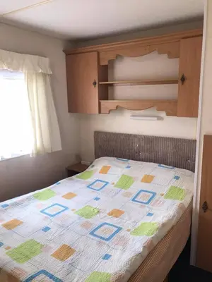 a bedroom with a bed with a quilt on it at Rooms for Rent near Vilnius in Bezdonys