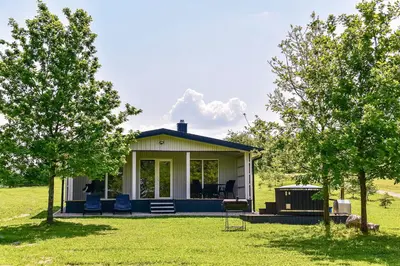 a small house in a field with two trees at 5 Nameliai in Kudariškės