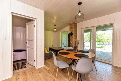 a room with a table and chairs and a bedroom at 5 Nameliai in Kudariškės