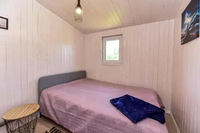 a small bedroom with a bed and a window at 5 Nameliai in Kudariškės