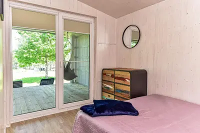 a bedroom with a bed and a sliding glass door at 5 Nameliai in Kudariškės