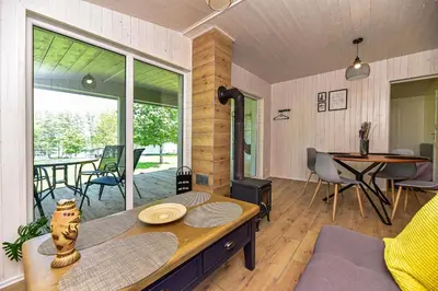 a living room with a table and a large window at 5 Nameliai in Kudariškės
