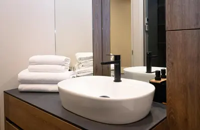 a bathroom with a white sink and a toilet at Apartment w-Terrace I Air Condition I New building I Self Check-In in Birštonas