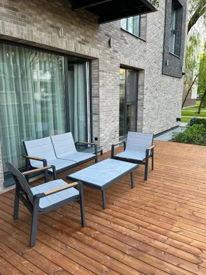 three chairs and a table on a wooden deck at Apartment w-Terrace I Air Condition I New building I Self Check-In in Birštonas