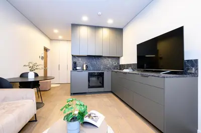 a living room with a large kitchen with a tv at Apartment w-Terrace I Air Condition I New building I Self Check-In in Birštonas