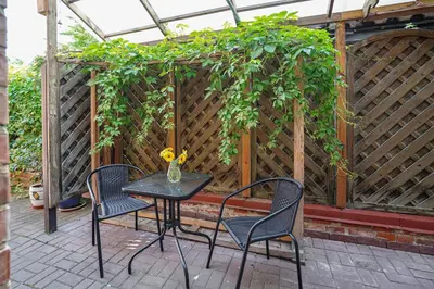 a table and chairs on a patio with a pergola at Exclusive OldNew apartments in city center in Panevėžys