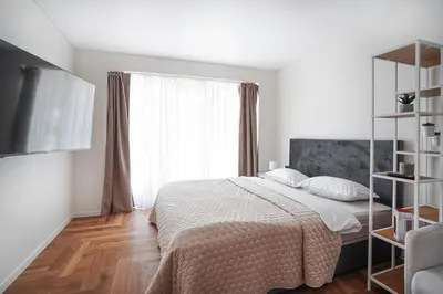 a bedroom with a bed and a large window at Exclusive OldNew apartments in city center in Panevėžys