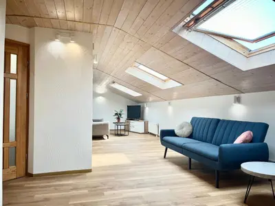 a living room with a blue couch and skylights at Exclusive OldNew apartments in city center in Panevėžys