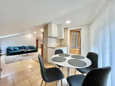 a kitchen and a living room with a table and chairs at Exclusive OldNew apartments in city center in Panevėžys