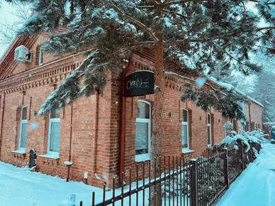 a brick building with a sign on it in the snow at Exclusive OldNew apartments in city center in Panevėžys