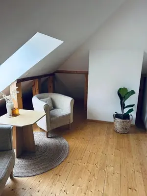 a living room with a table and a chair at In heart of Trakai you'll find authentic Karaim house in Trakai