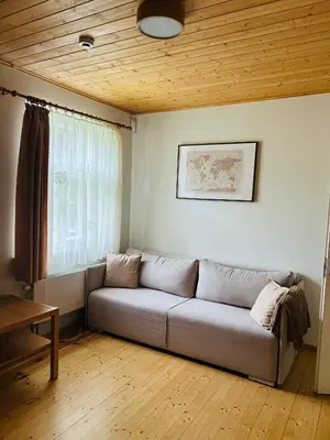 a couch in a living room with a wooden ceiling at In heart of Trakai you'll find authentic Karaim house in Trakai