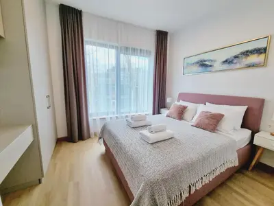 a bedroom with a bed and a large window at MELODIJA apartments in Druskininkai center in Druskininkai