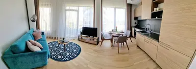 a living room with a blue couch and a table at MELODIJA apartments in Druskininkai center in Druskininkai